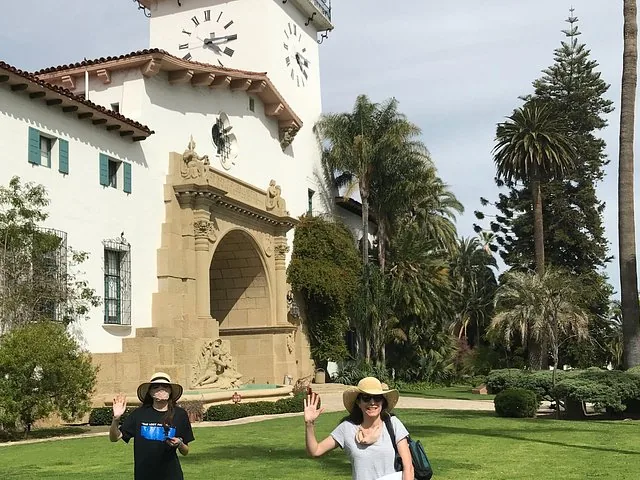Deux femmes portant des chapeaux debout devant le Santa Barbara County Courthouse.