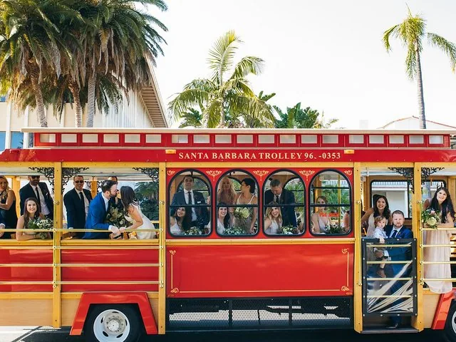Groupe de personnes posant pour une photo à l'intérieur d'un Santa Barbara Trolley rouge.