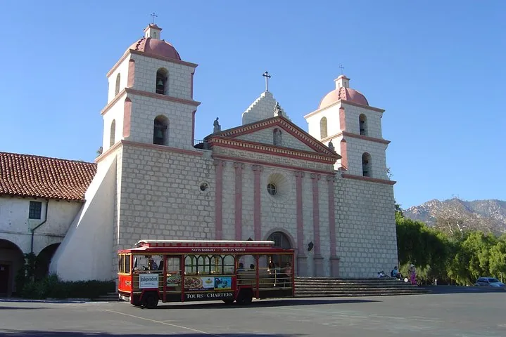 Tramway rouge garé devant la Mission Santa Barbara par une journée ensoleillée.